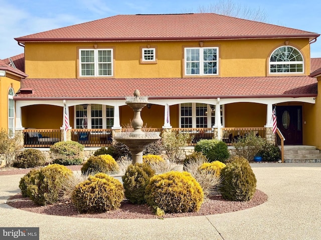 view of front facade featuring a tile roof and stucco siding