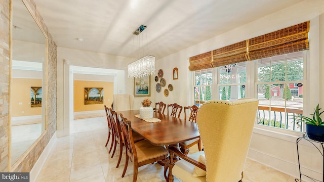 dining room featuring a wealth of natural light, a notable chandelier, baseboards, and light tile patterned floors