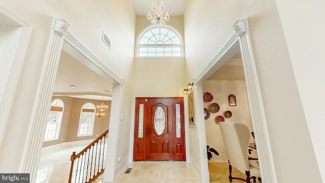 foyer featuring a chandelier, a high ceiling, visible vents, and a wealth of natural light