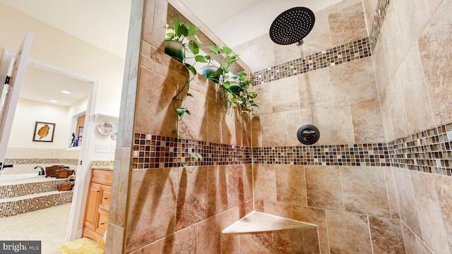 room details featuring a garden tub, a tile shower, and vanity