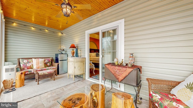 sunroom featuring a ceiling fan and wooden ceiling
