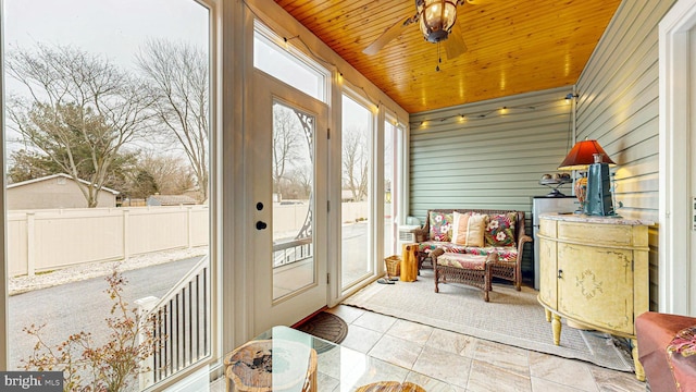 sunroom / solarium featuring wood ceiling and a ceiling fan