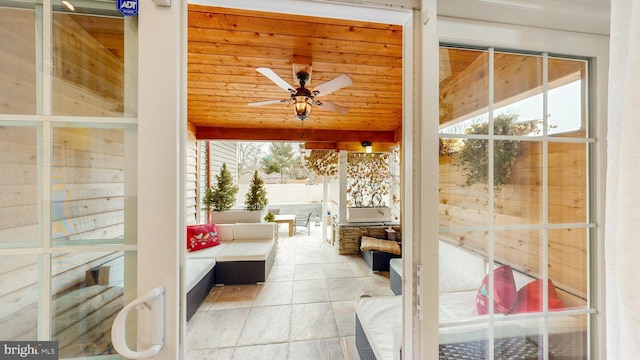 sunroom / solarium featuring wooden ceiling, ceiling fan, and a wealth of natural light