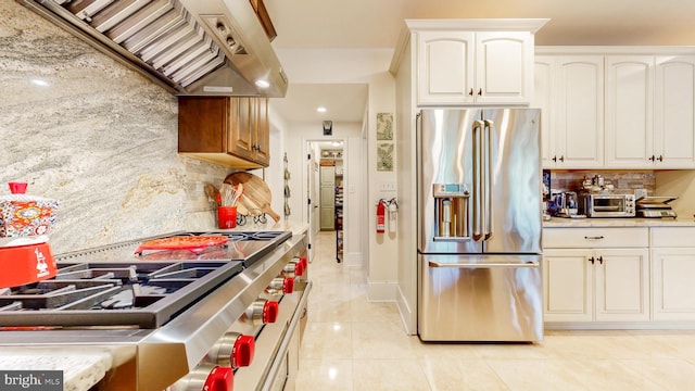 kitchen featuring premium appliances, white cabinets, custom range hood, and light tile patterned floors