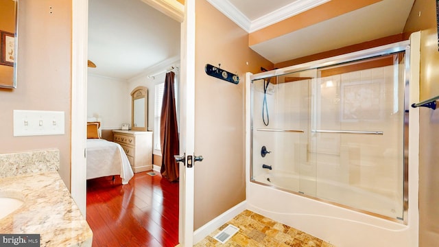 ensuite bathroom with enclosed tub / shower combo, connected bathroom, visible vents, baseboards, and crown molding
