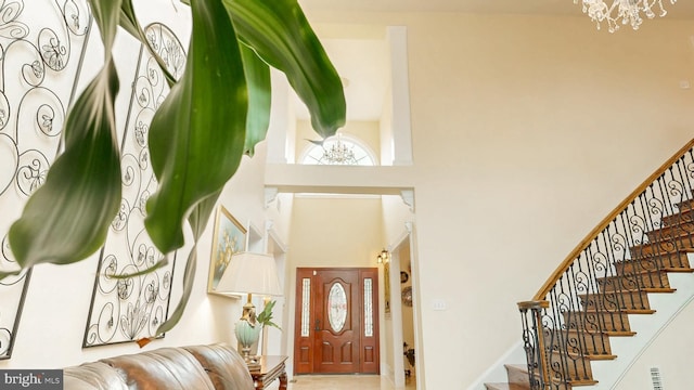 foyer featuring stairway, a towering ceiling, and an inviting chandelier