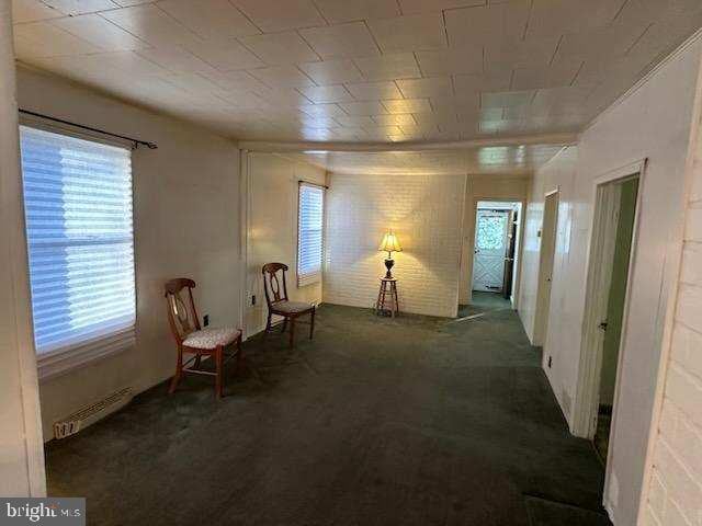 sitting room featuring dark colored carpet