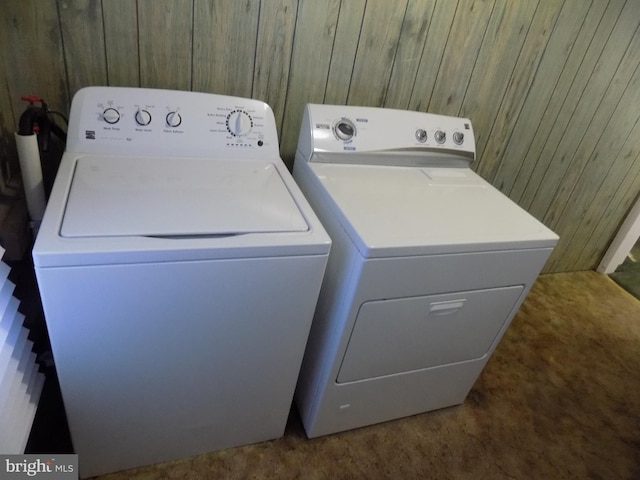 washroom featuring separate washer and dryer and wood walls