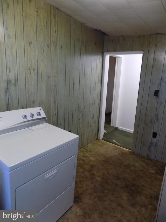 laundry area with washer / dryer, dark carpet, and wood walls