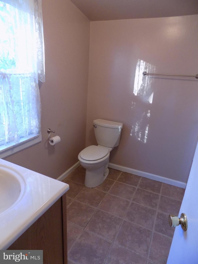 bathroom featuring vanity, tile patterned flooring, and toilet