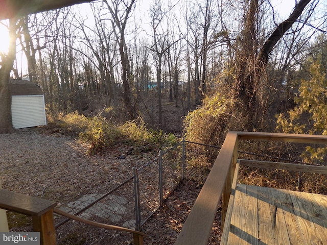 view of yard with a wooden deck and a storage shed