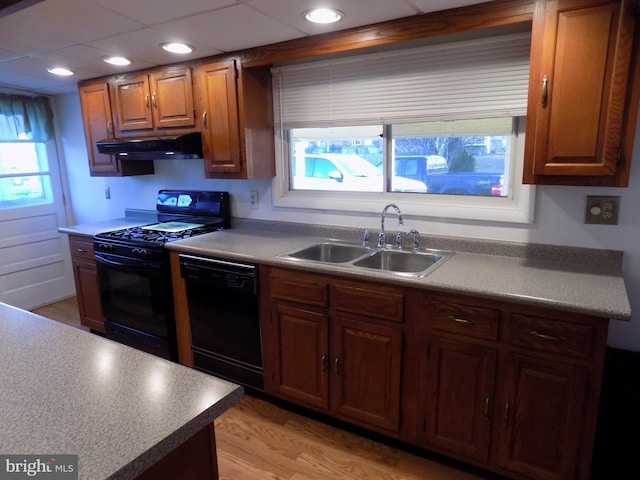 kitchen featuring sink, light hardwood / wood-style flooring, and black appliances