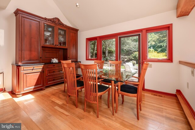 dining area with lofted ceiling, light wood finished floors, visible vents, and baseboards