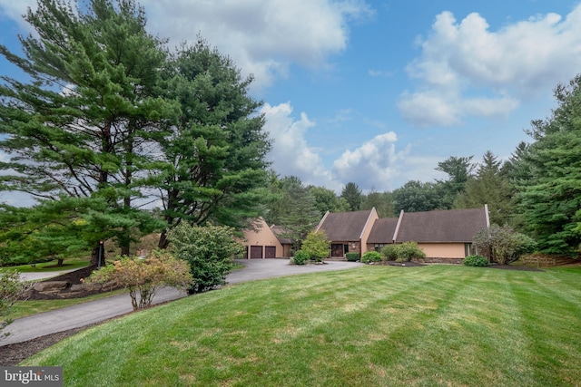 view of front of home featuring a garage, driveway, and a front yard