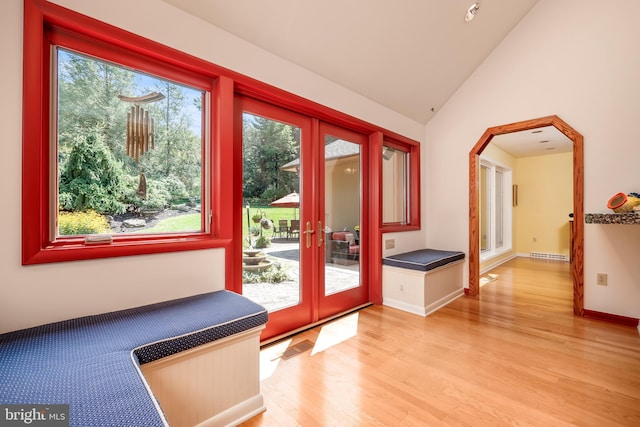 doorway to outside featuring baseboards, visible vents, vaulted ceiling, french doors, and light wood-style floors