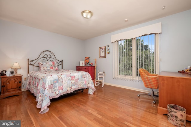 bedroom with baseboards and wood finished floors