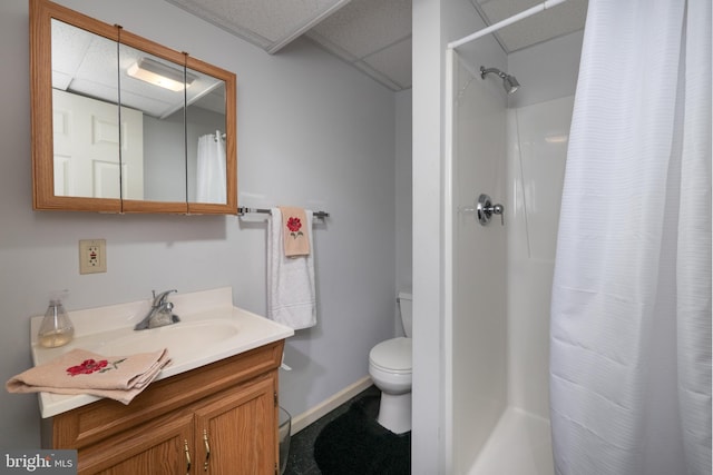 full bath with a shower with shower curtain, a drop ceiling, and toilet