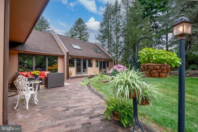 rear view of property featuring a shingled roof, an outdoor hangout area, a patio, and a yard