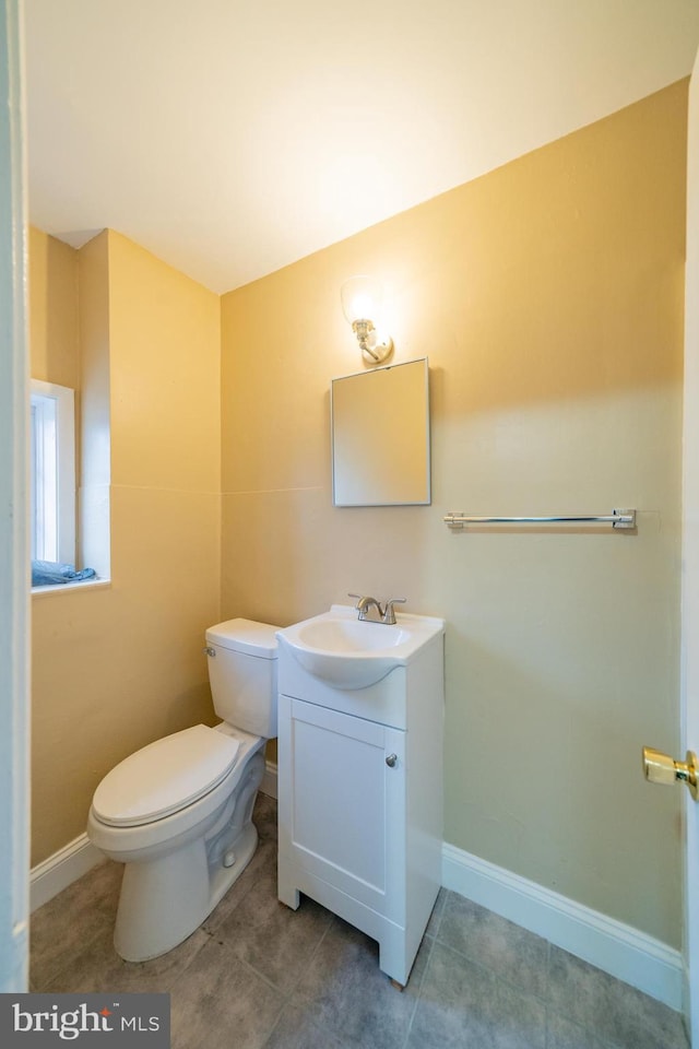 bathroom featuring vanity, tile patterned flooring, and toilet