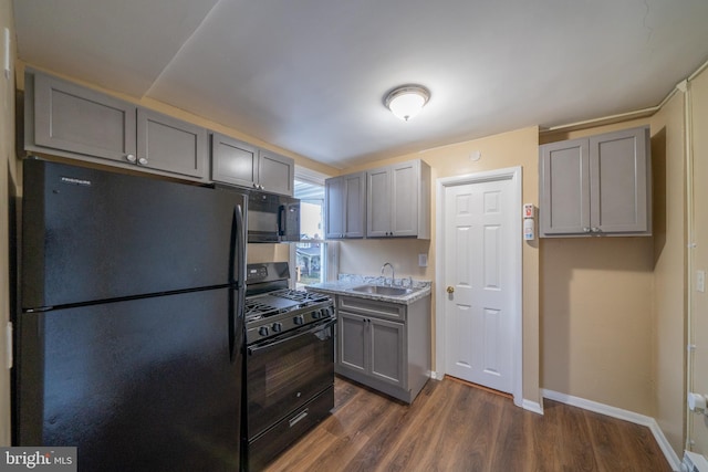 kitchen featuring gray cabinetry, sink, dark hardwood / wood-style flooring, and black appliances