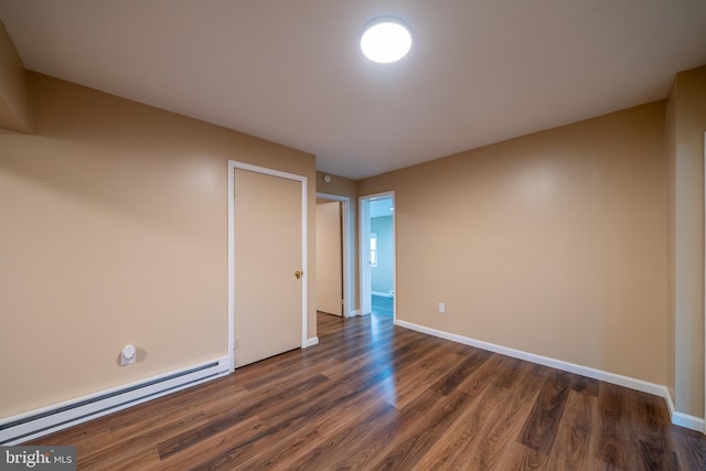 unfurnished room with dark hardwood / wood-style flooring and baseboard heating