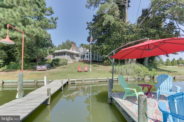 dock area featuring a water view and a lawn