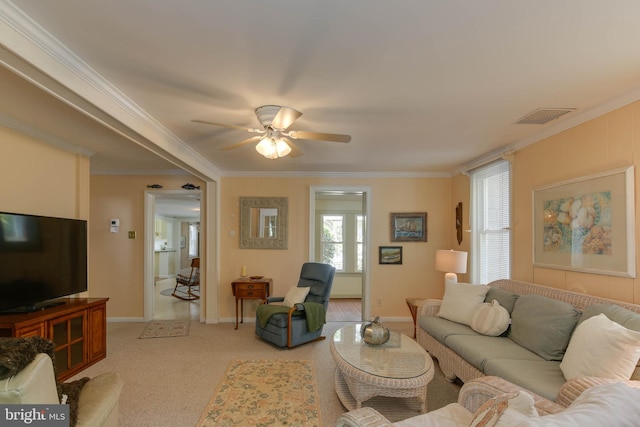 carpeted living room with crown molding, ceiling fan, and a wealth of natural light