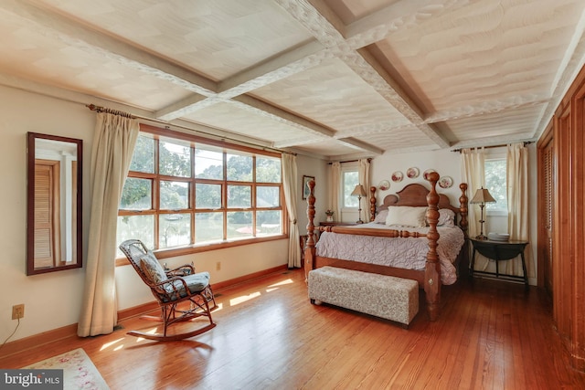 bedroom with coffered ceiling, hardwood / wood-style floors, and beam ceiling