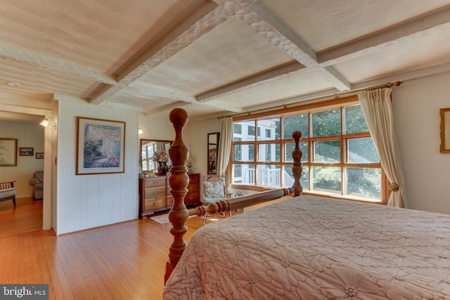 bedroom featuring beamed ceiling, coffered ceiling, and light hardwood / wood-style flooring