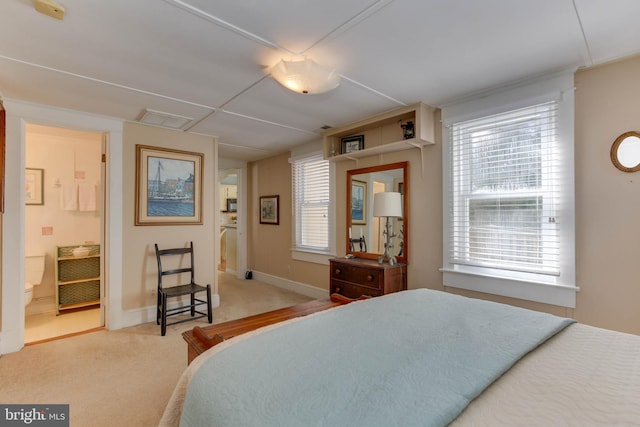 bedroom with ensuite bathroom and carpet