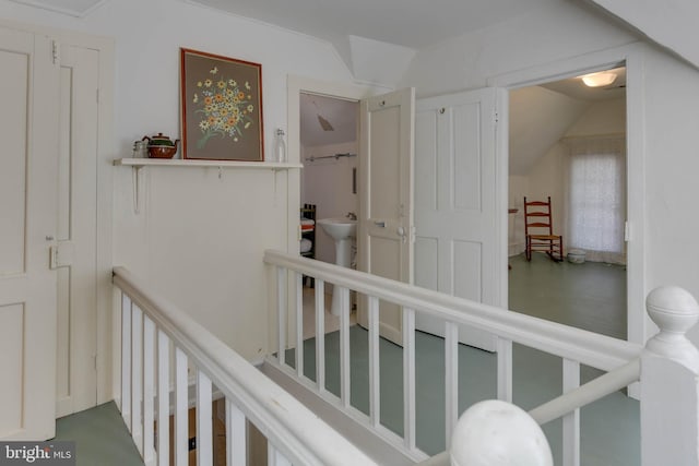 hallway featuring lofted ceiling and sink