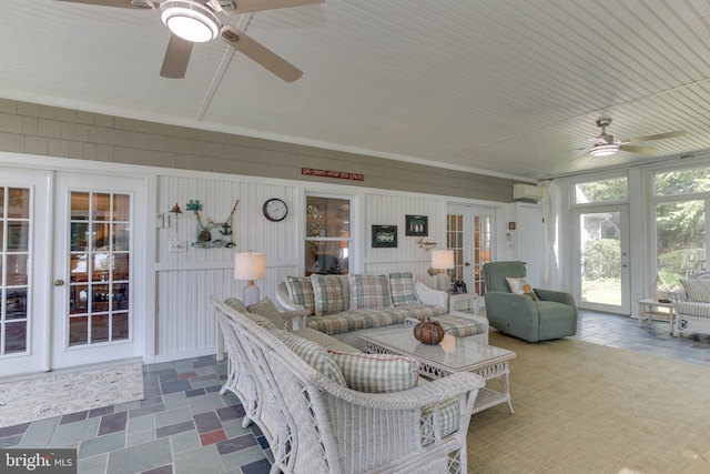 living room with a wall mounted air conditioner, ceiling fan, and french doors