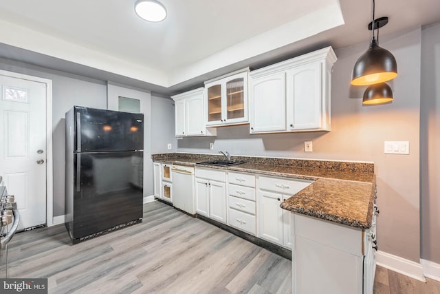 kitchen with black fridge, white cabinets, decorative light fixtures, and white dishwasher