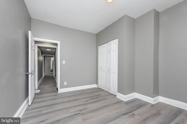 unfurnished bedroom featuring a closet and light hardwood / wood-style flooring