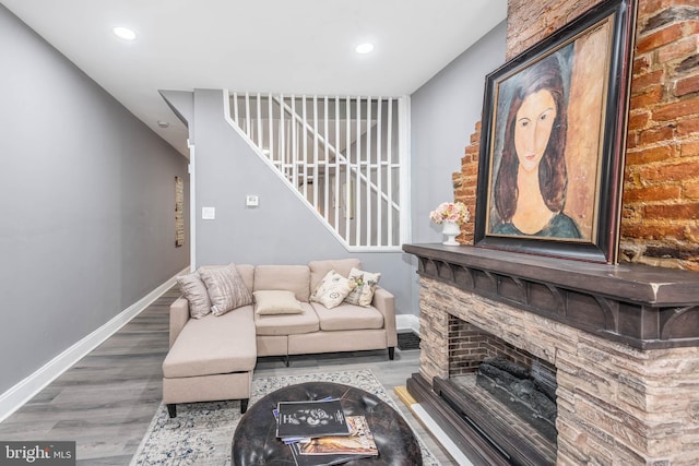 living room featuring wood-type flooring and a fireplace