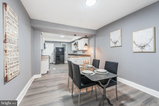 dining room with sink and light wood-type flooring