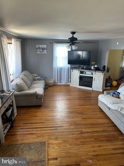 living room with wood-type flooring and ceiling fan