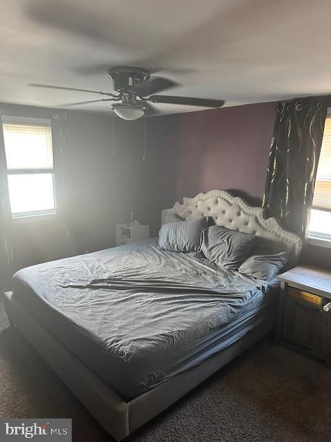 bedroom featuring dark colored carpet and ceiling fan