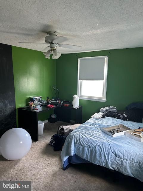 bedroom featuring a textured ceiling, ceiling fan, and carpet flooring