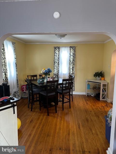 dining area with crown molding and hardwood / wood-style floors