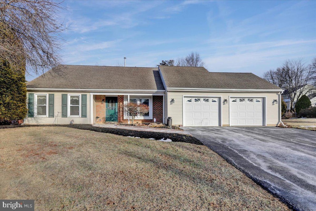 single story home featuring a garage and a front lawn