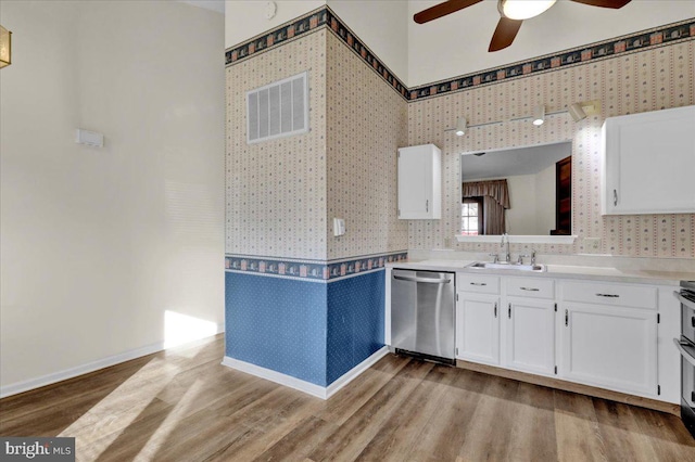 kitchen featuring sink, dishwasher, ceiling fan, white cabinetry, and light hardwood / wood-style floors