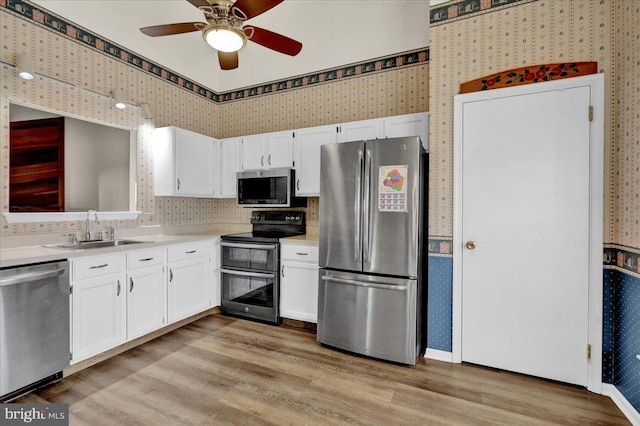 kitchen with sink, white cabinetry, ceiling fan, stainless steel appliances, and light hardwood / wood-style floors