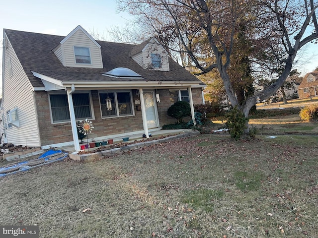 cape cod house featuring a front yard and a porch