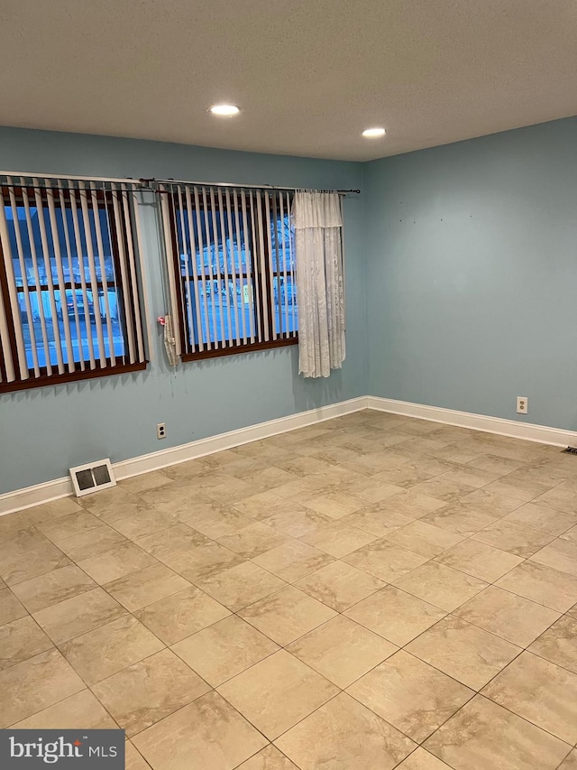 spare room with a textured ceiling