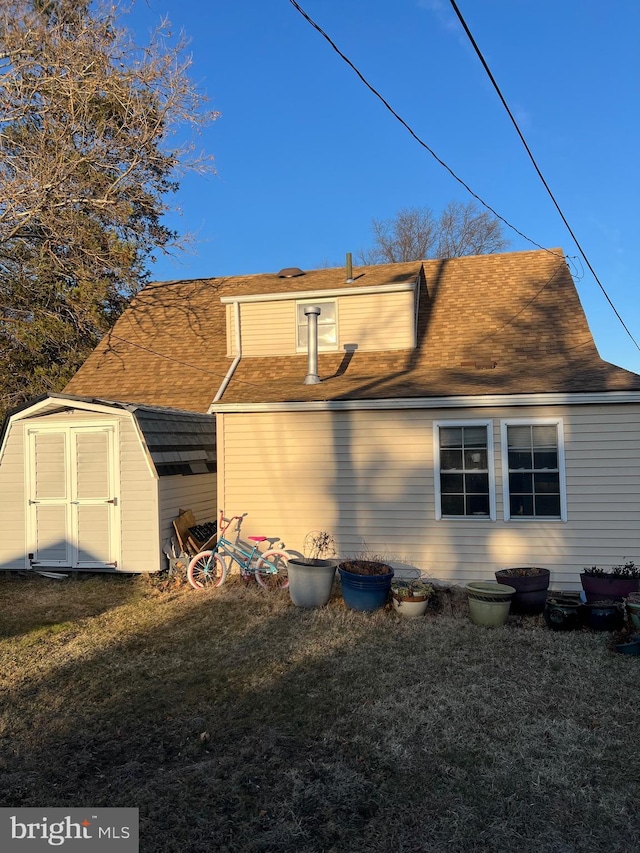 rear view of property with a yard and a shed