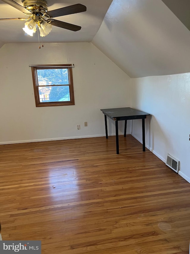 additional living space with lofted ceiling, dark hardwood / wood-style floors, and ceiling fan