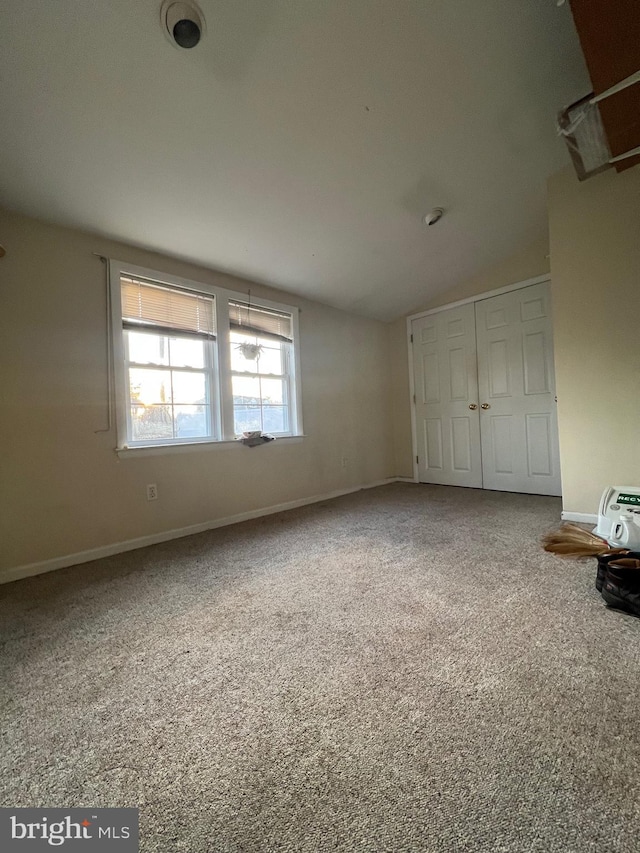 unfurnished bedroom with lofted ceiling and a closet