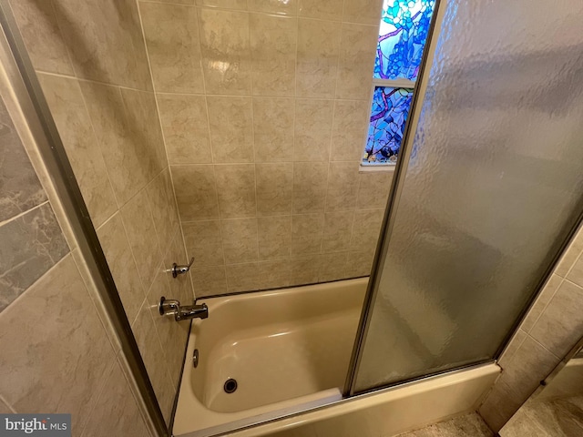 bathroom featuring bath / shower combo with glass door