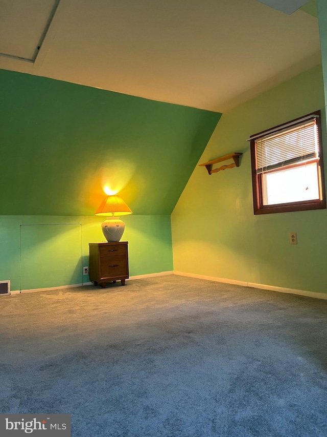 bonus room with vaulted ceiling and carpet floors